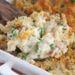 tuna noodles in a white baking dish with a wooden spoon