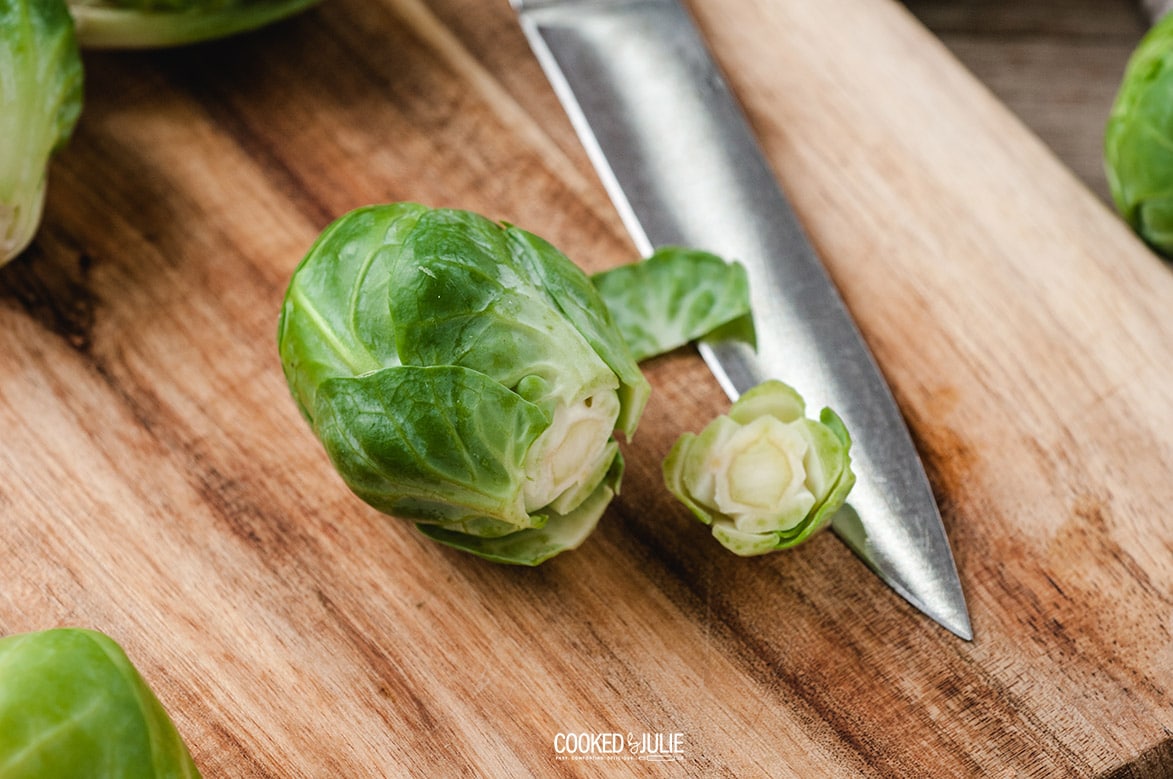 brussel sprouts on a wooden board with a knife 
