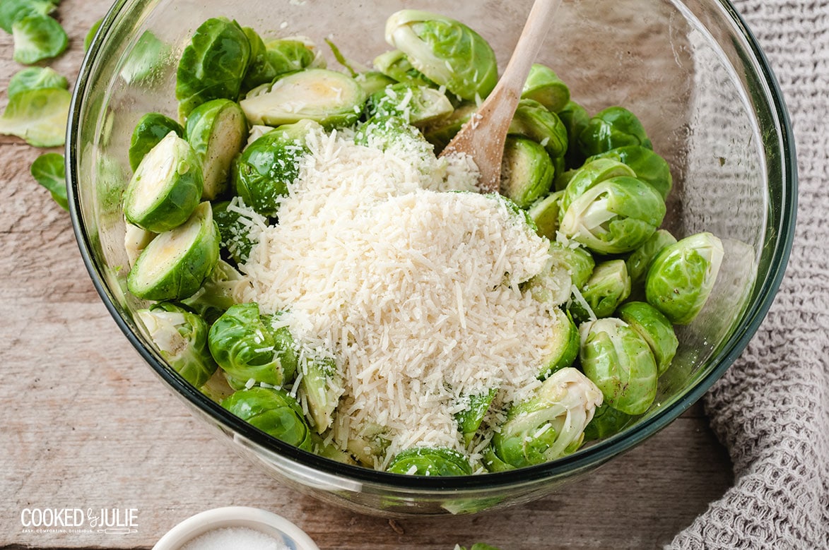 parmesan cheese and brussel sprouts with a wooden spoon in a bowl 