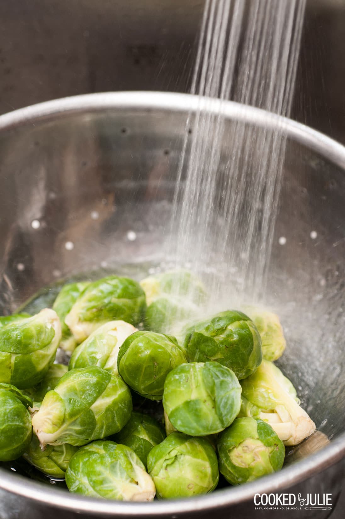brussel sprouts under cold water in a colander 
