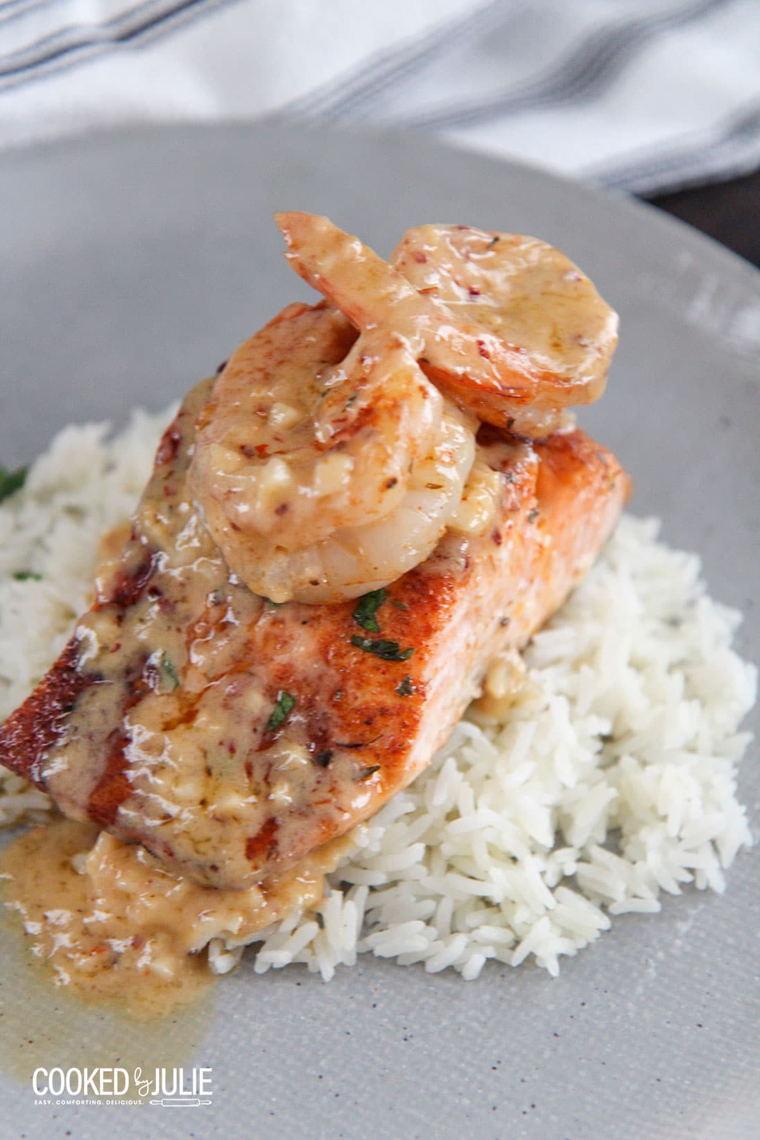 salmon and shrimp over white rice on a plate