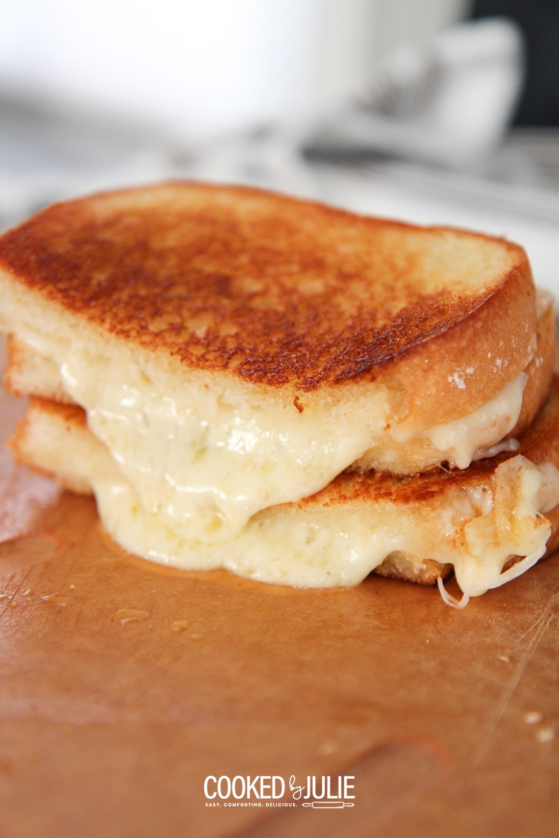 two grilled cheese sandwiches on a wooden board