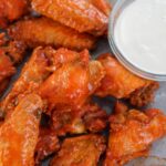 baked buffalo wings on a gray plate with a side of bleu cheese