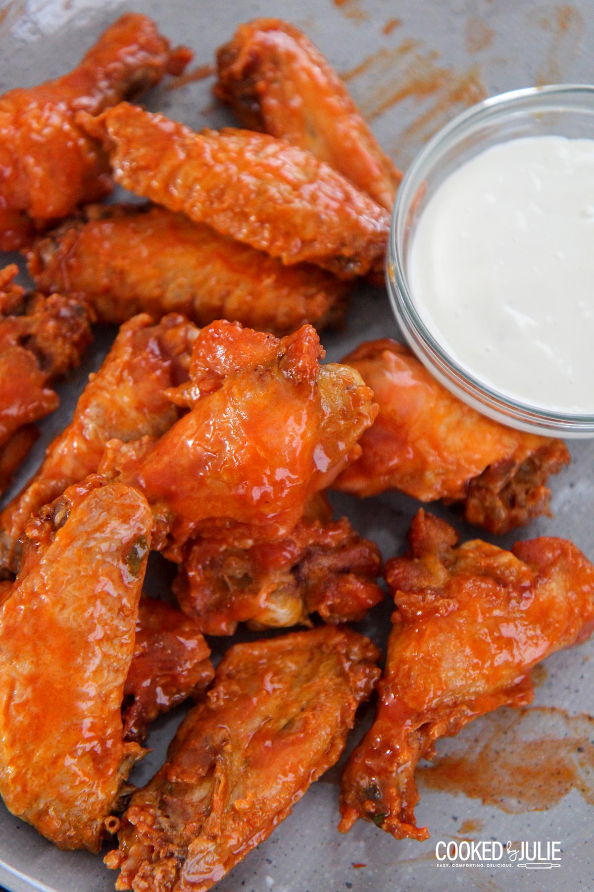 baked buffalo wings on a gray plate with a side of bleu cheese