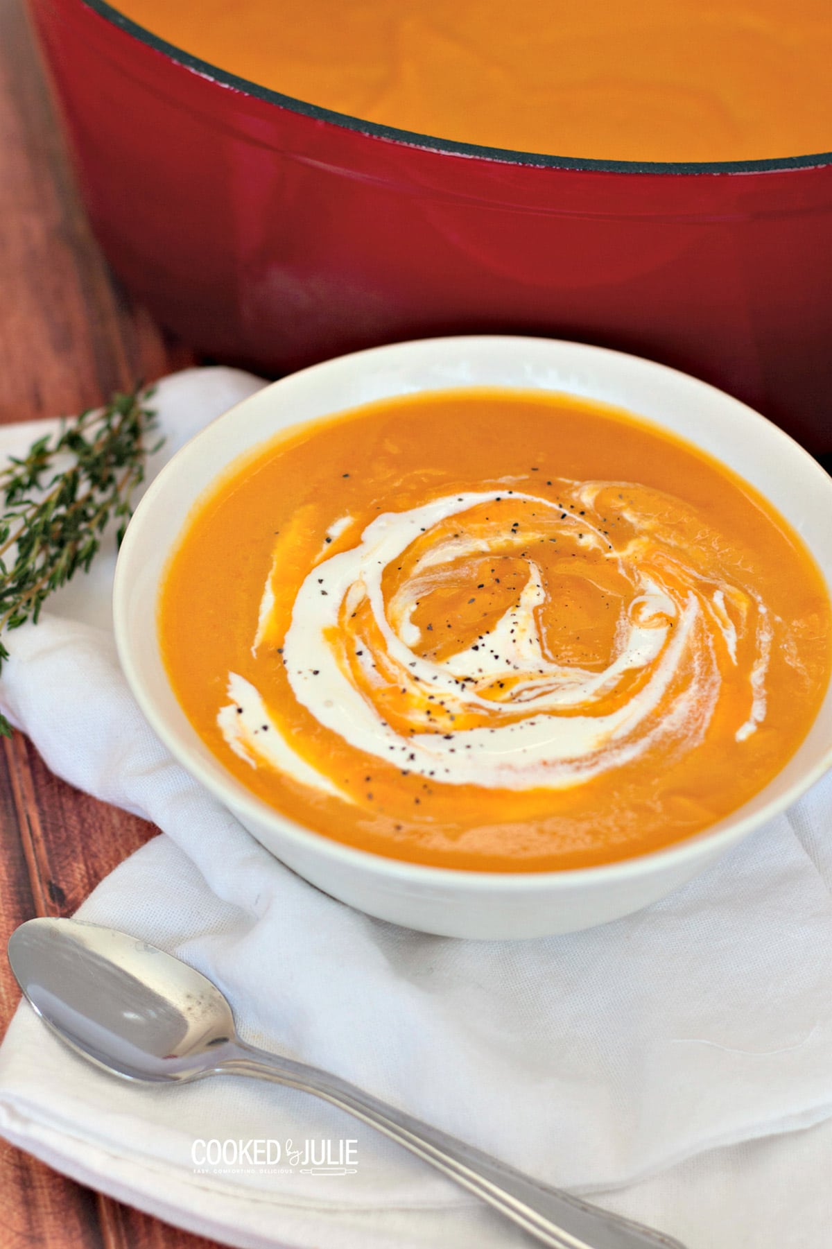 roasted butternut squash soup in a white bowl with a spoon on the side