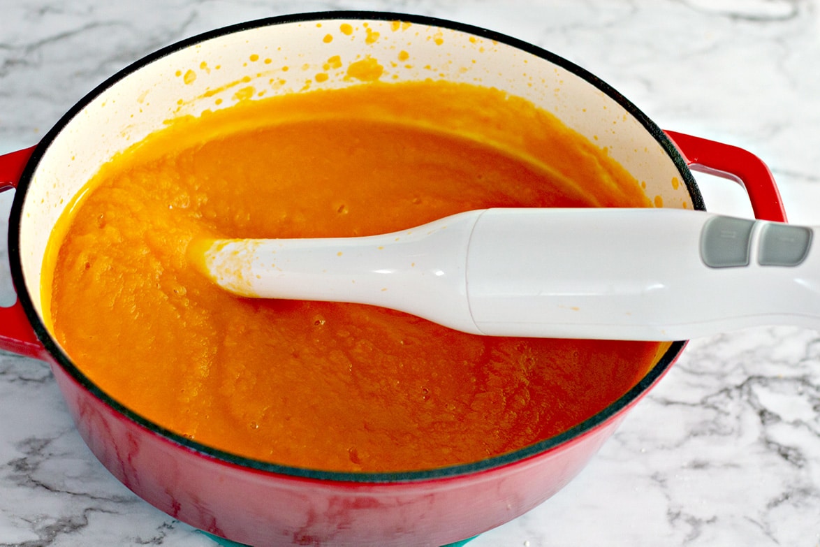 pureed soup in a dutch oven with an immersion blender 