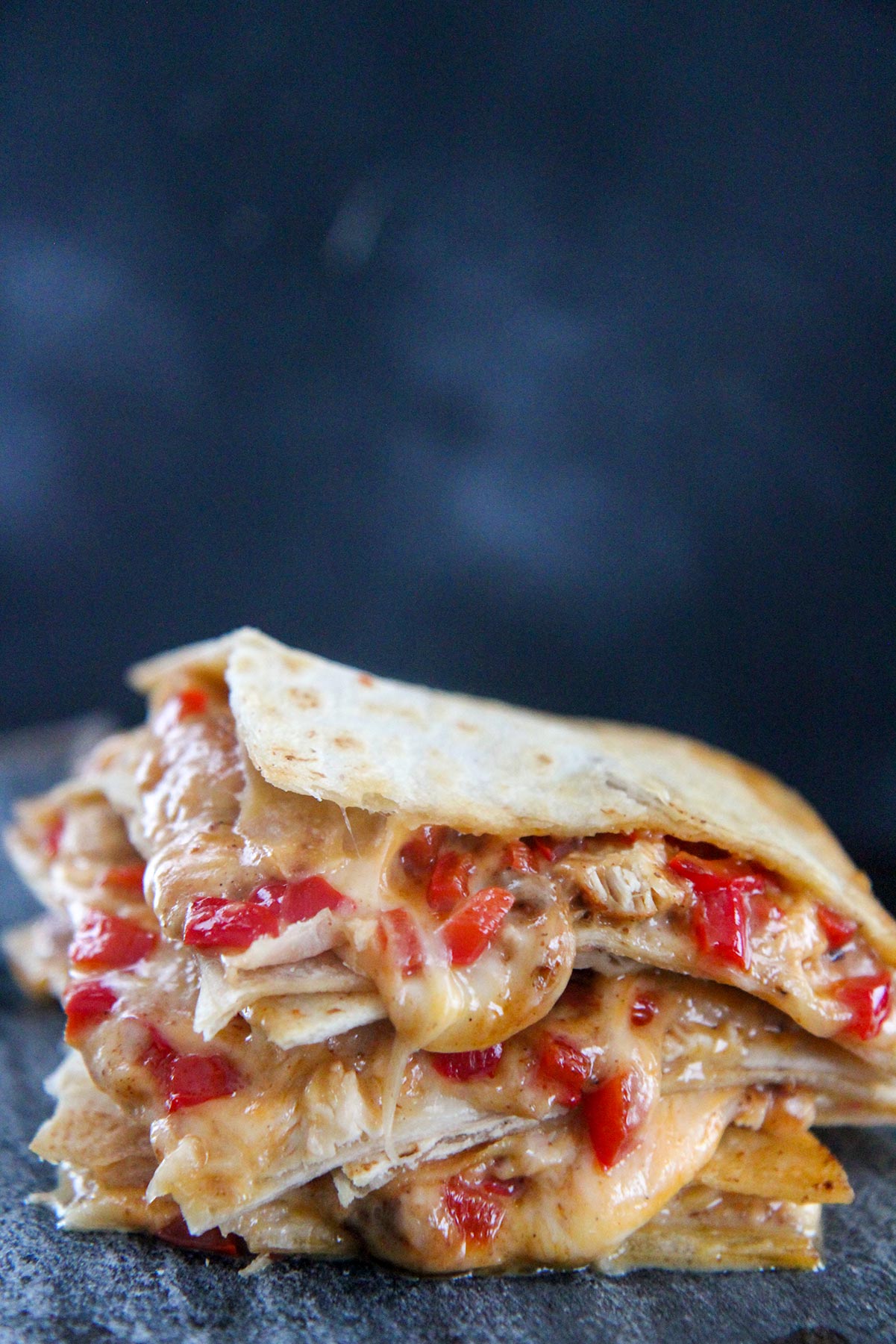 four cheesy chicken quesadillas stacked up close 