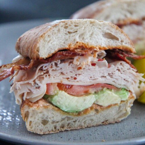 turkey bacon avocado sandwich on a gray plate