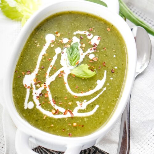 vegan green detox soup with cream in a white bowl