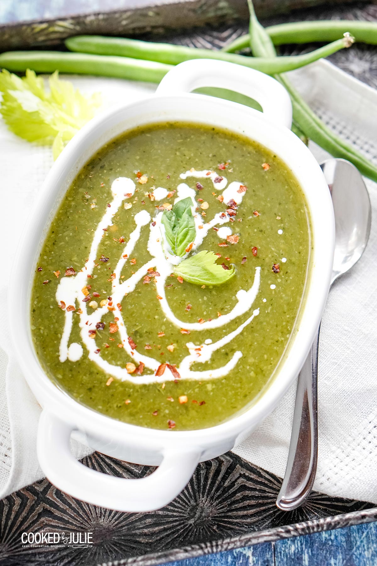 vegan green detox soup with cream in a white bowl 
