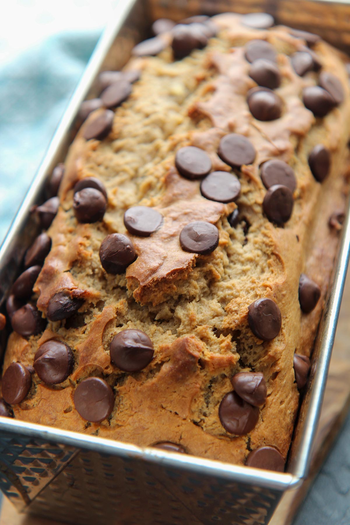 baked banana bread with chocolate chips on top in a loaf pan. 