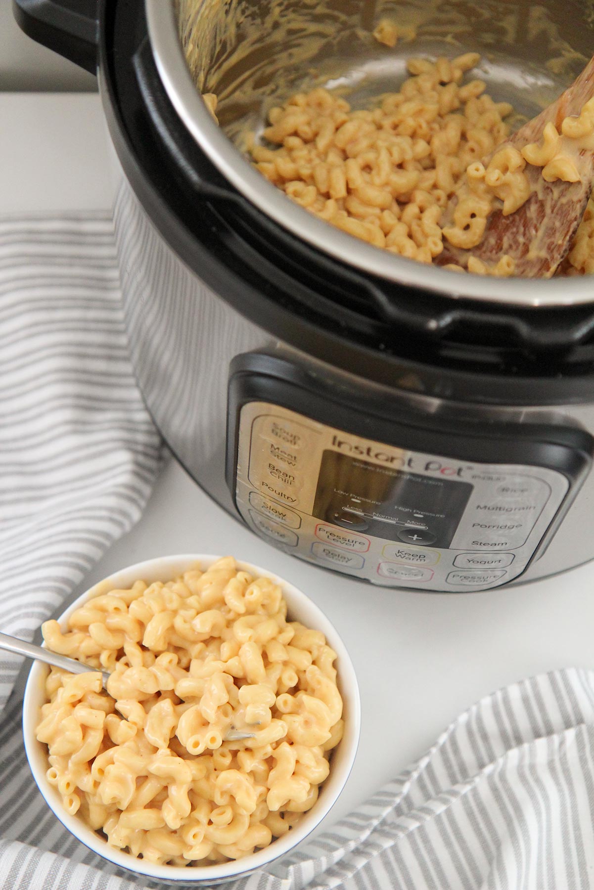 a small bowl filled with mac and cheese and an instant pot with mac and cheese in the background. 