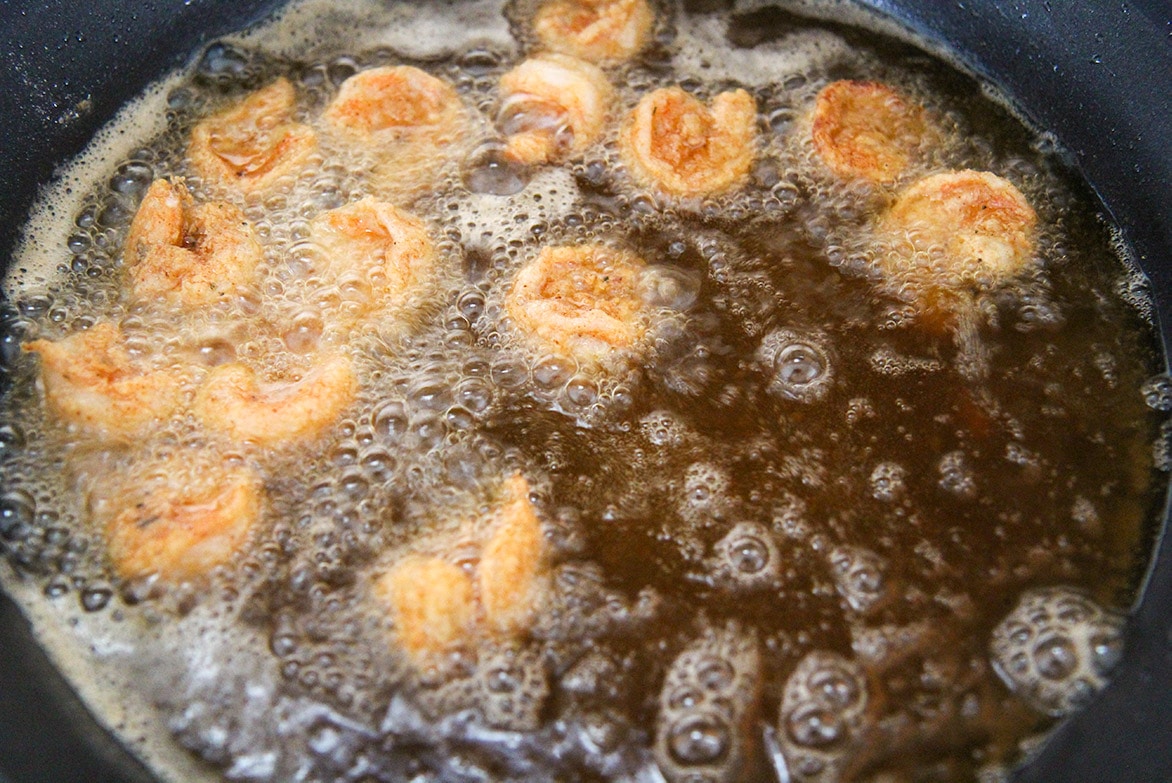 fried shrimp in an iron skillet with oil. 