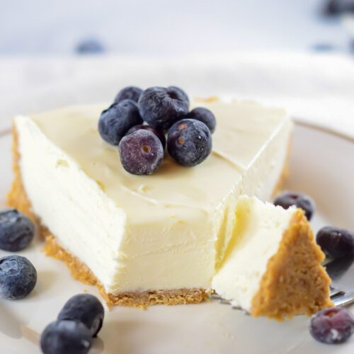 a fork slicing into a slice of cheesecake.