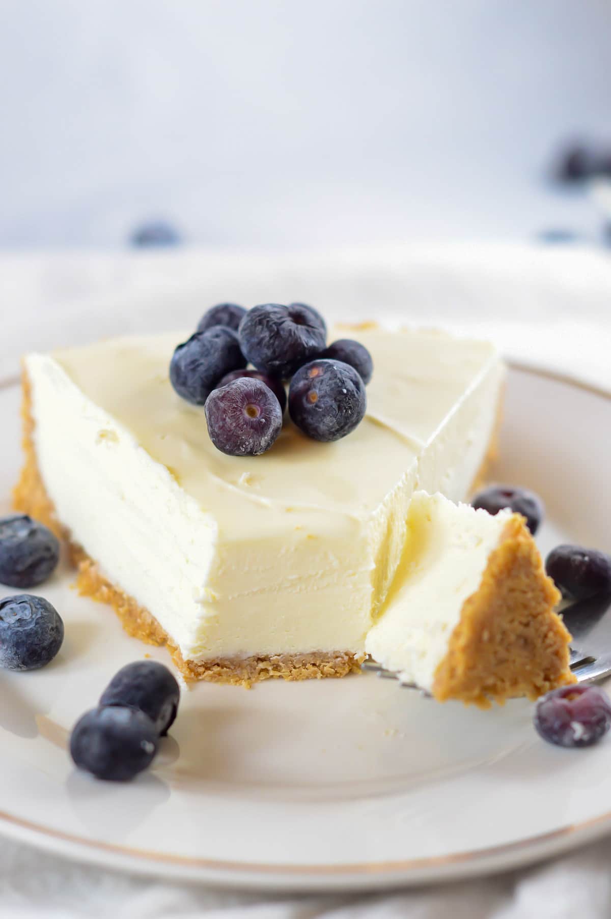 a fork slicing into a slice of cheesecake.