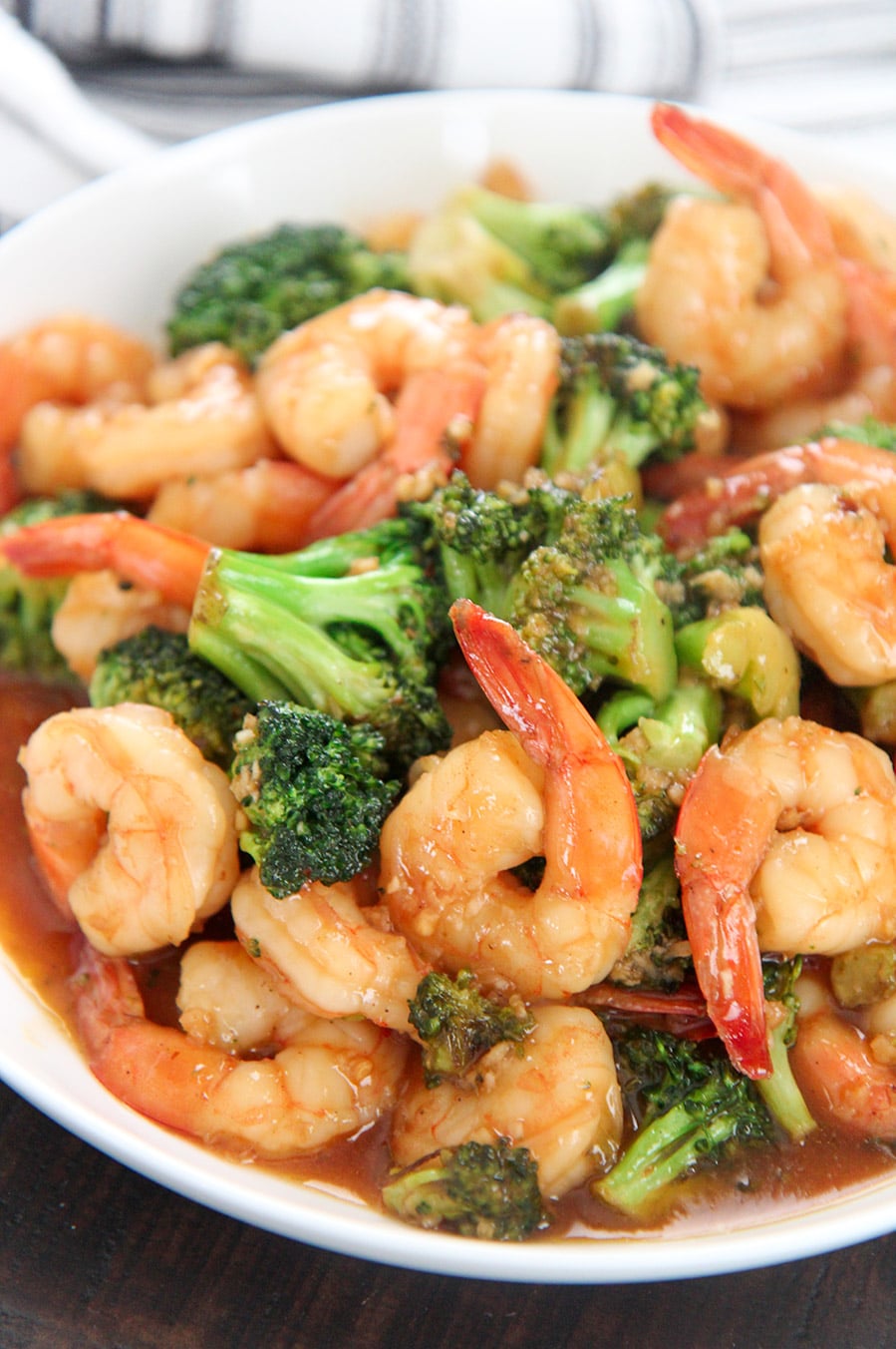 shrimp and broccoli with sauce in a white plate.