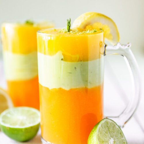 two tall glasses filled with Ethiopian spris and limes on the side.