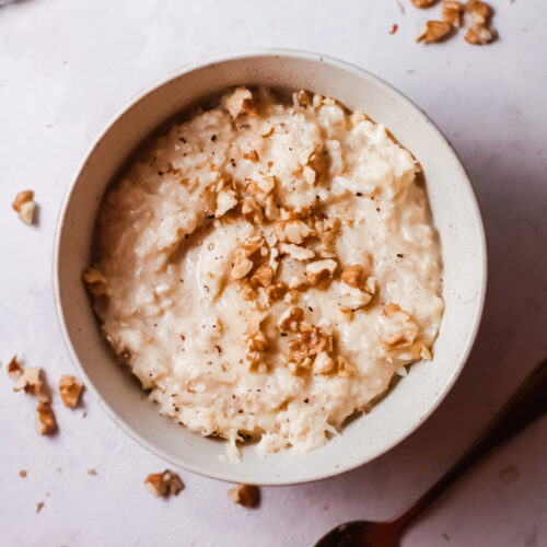 keto vegan risotto in a white bowl with a spoon on the side