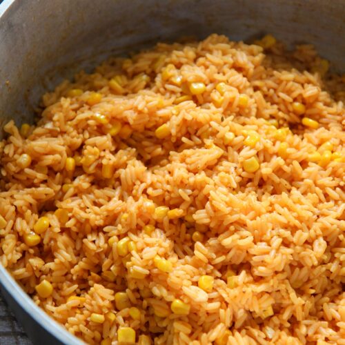 yellow rice with corn in a big pot.