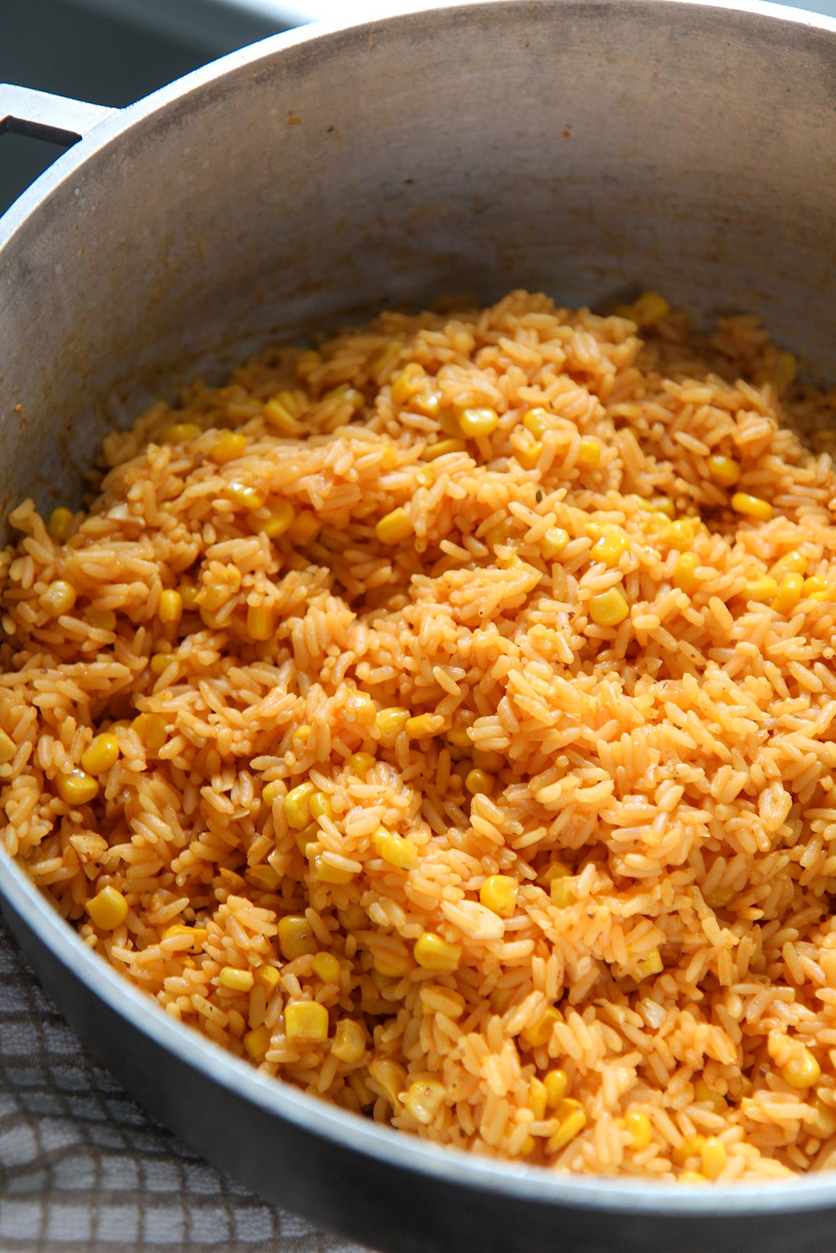 yellow rice with corn in a big pot. 