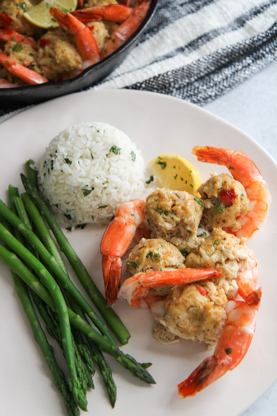 white rice, asparagus, and stuffed shrimp on a white plate. 