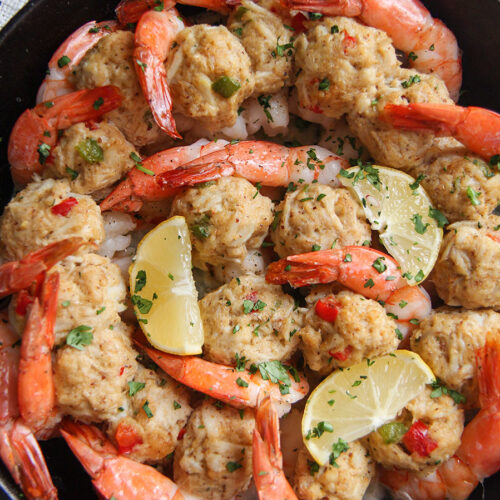 crab stuffed shrimp in a cast iron skillet with lemon wedges and parsley