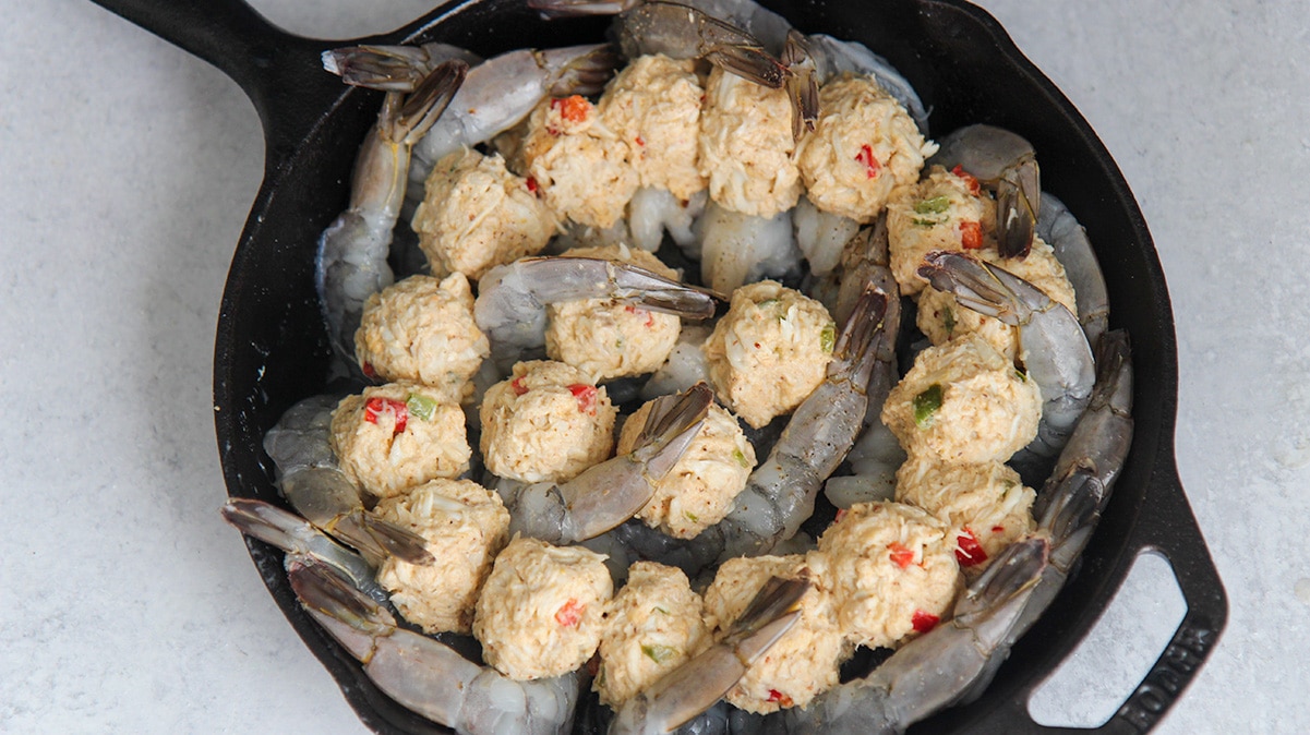 raw shrimp and crab filling in a black cast iron skillet. 