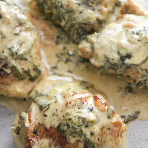 4 bone-in chicken thighs with spinach and cream on top.