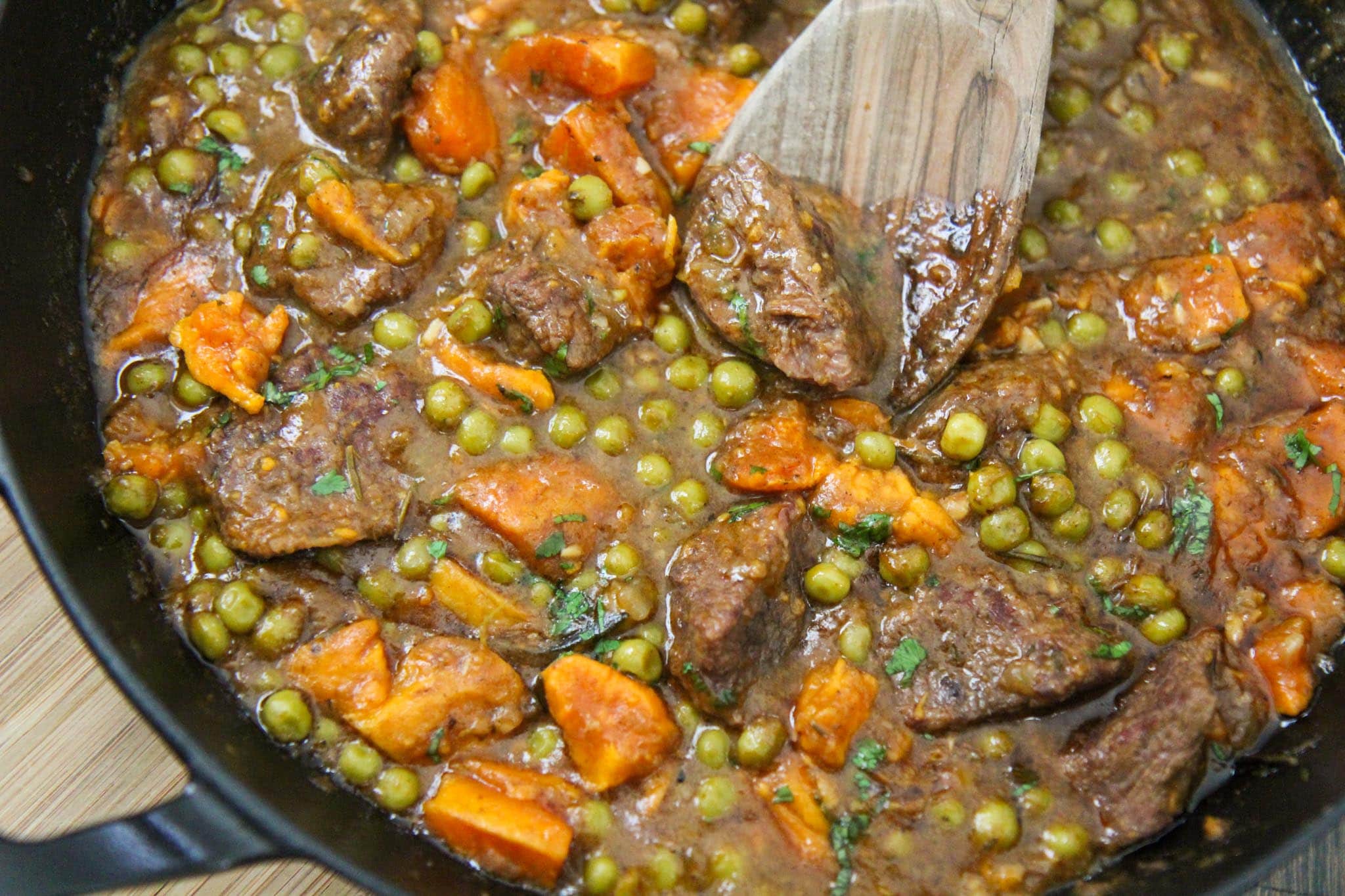 beef and sweet potatoes in a black skillet. 