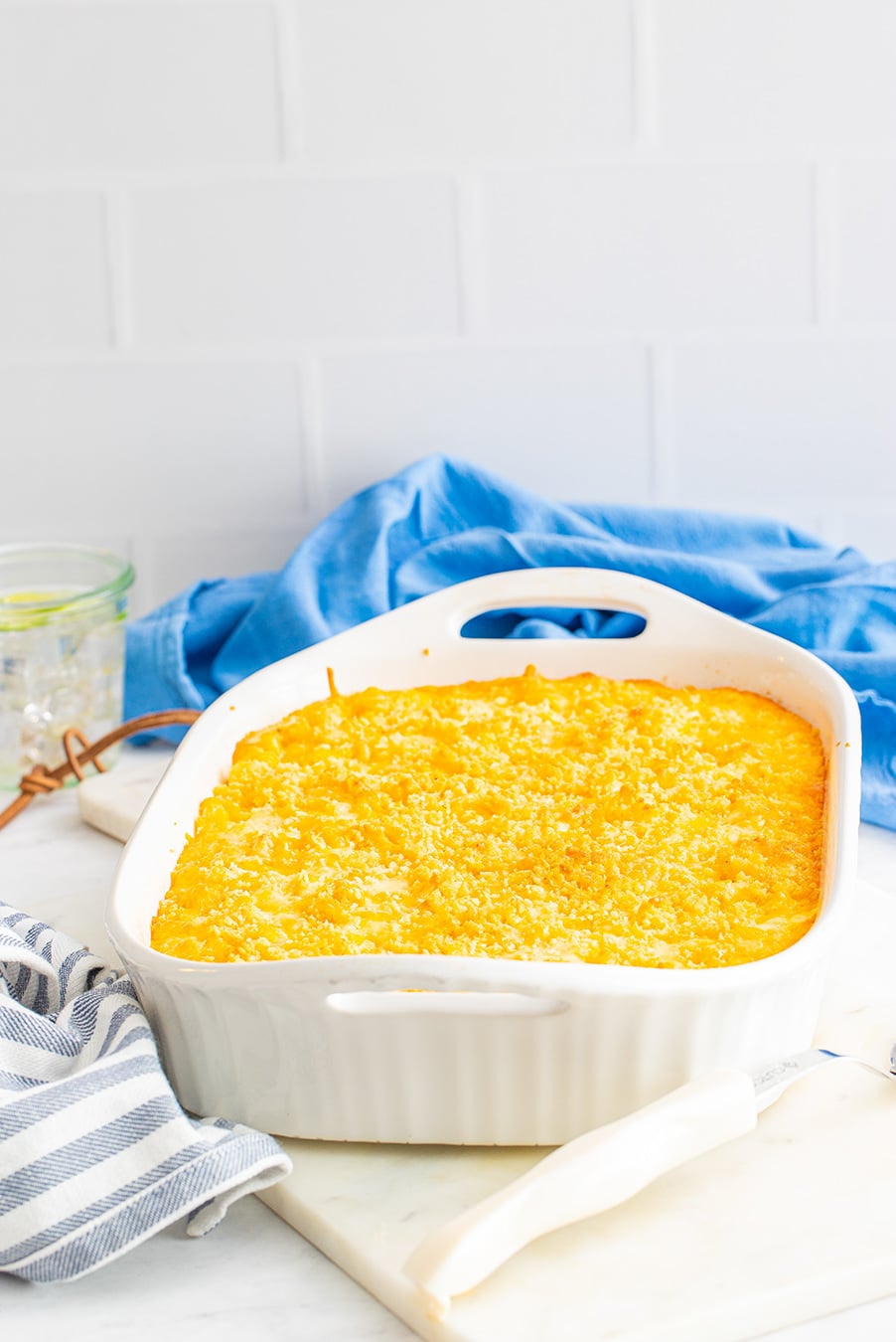 a white casserole dish filled with yellow mac and cheese. 