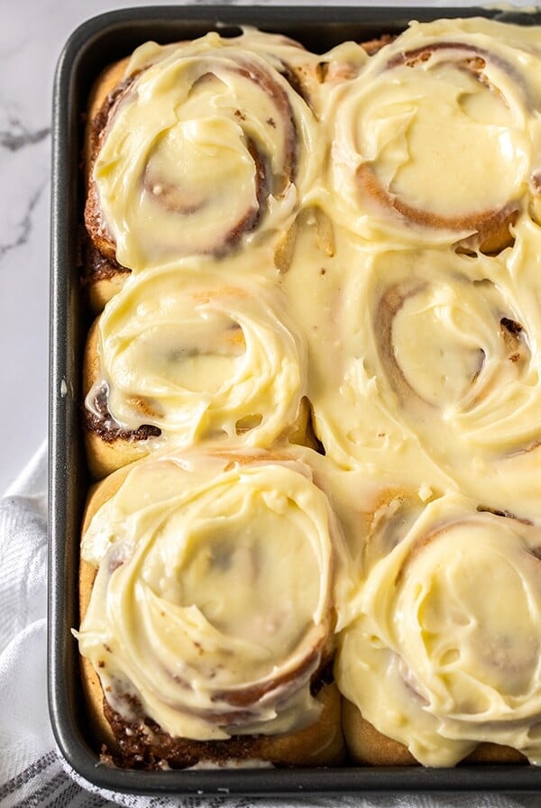 six jumbo cinnamon rolls with cream cheese frosting up close.