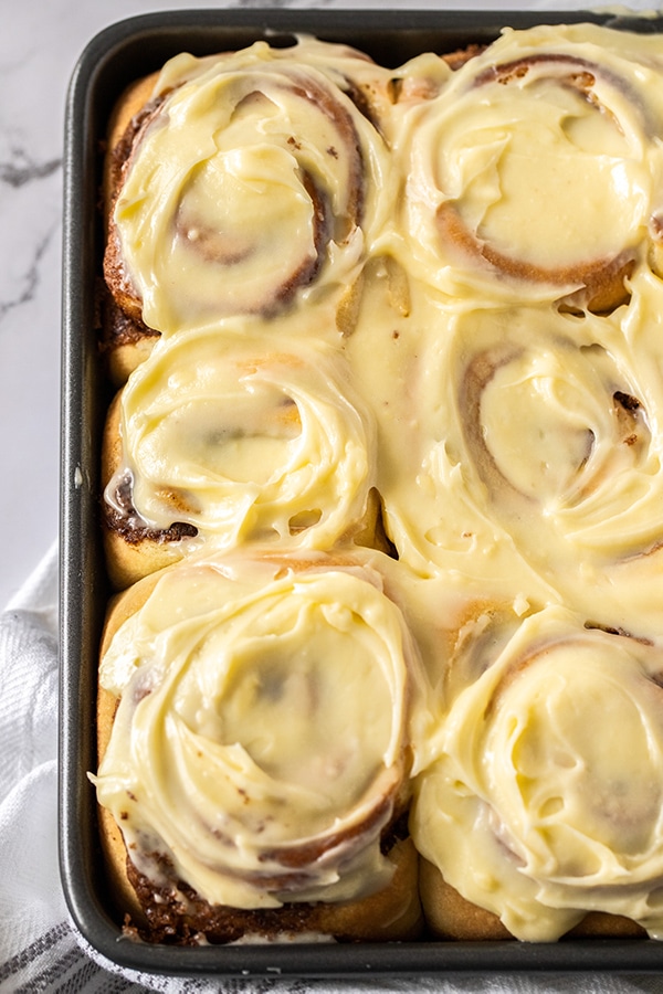 six jumbo cinnamon rolls with cream cheese frosting up close. 