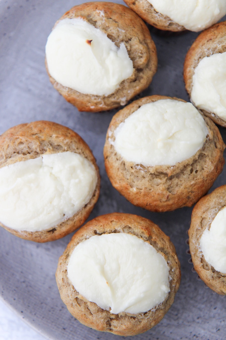 cream cheese banana muffins up close on a gray plate.