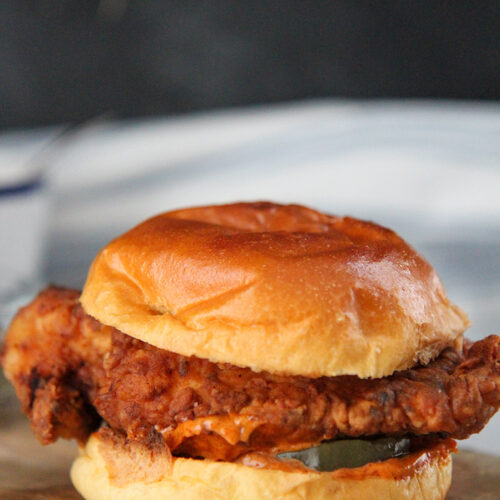 popeye's fried chicken sandwich on a wooden board.