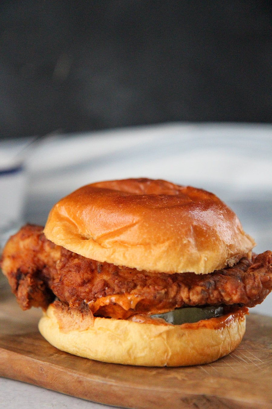 popeye's fried chicken sandwich on a wooden board.