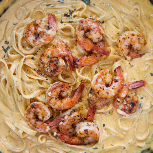 pumpkin fettuccine alfredo with shrimp in a cast iron skillet.