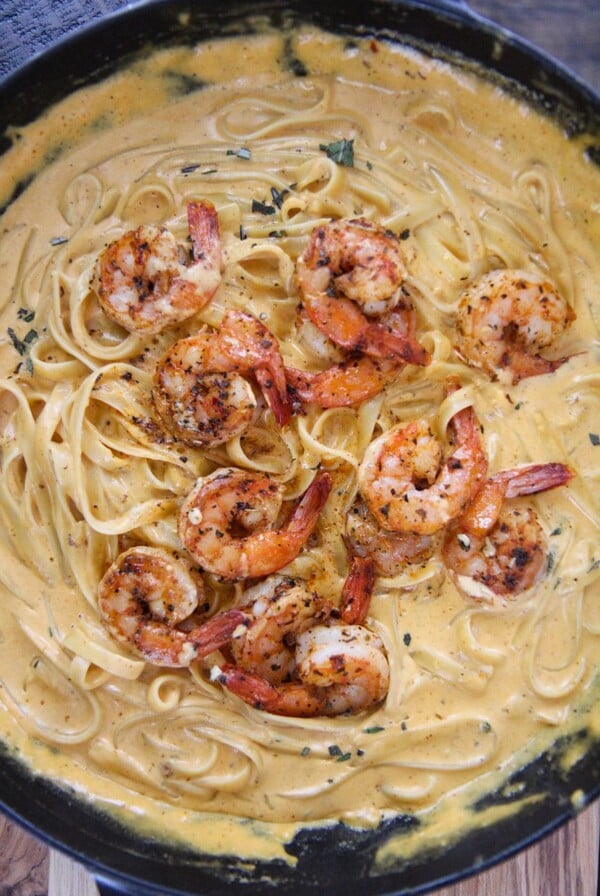 pumpkin fettuccine alfredo with shrimp in a cast iron skillet.
