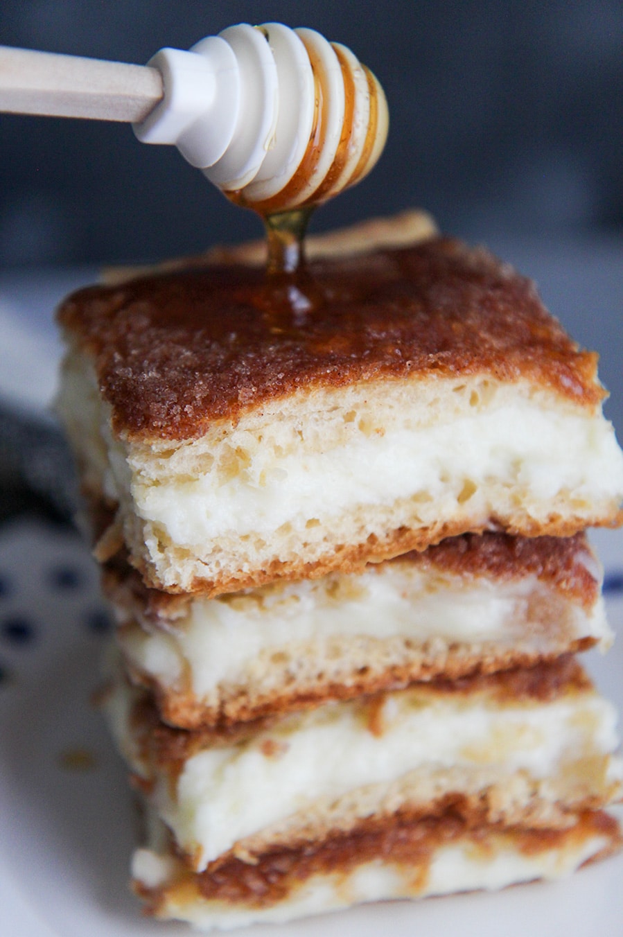 four sopapilla cheesecake bars with drizzled honey on top. 