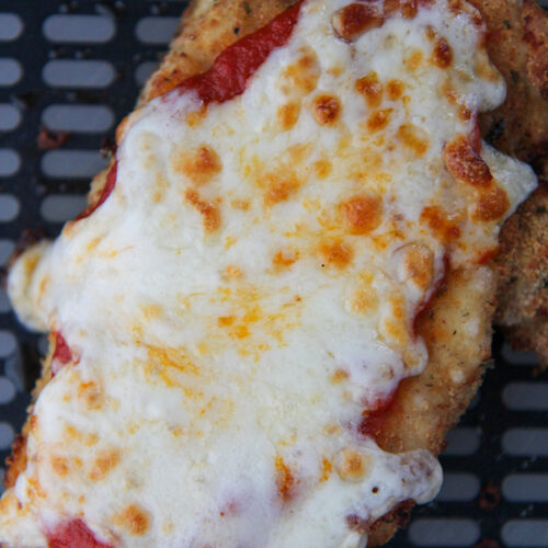 chicken parmesan in the black air fryer basket.