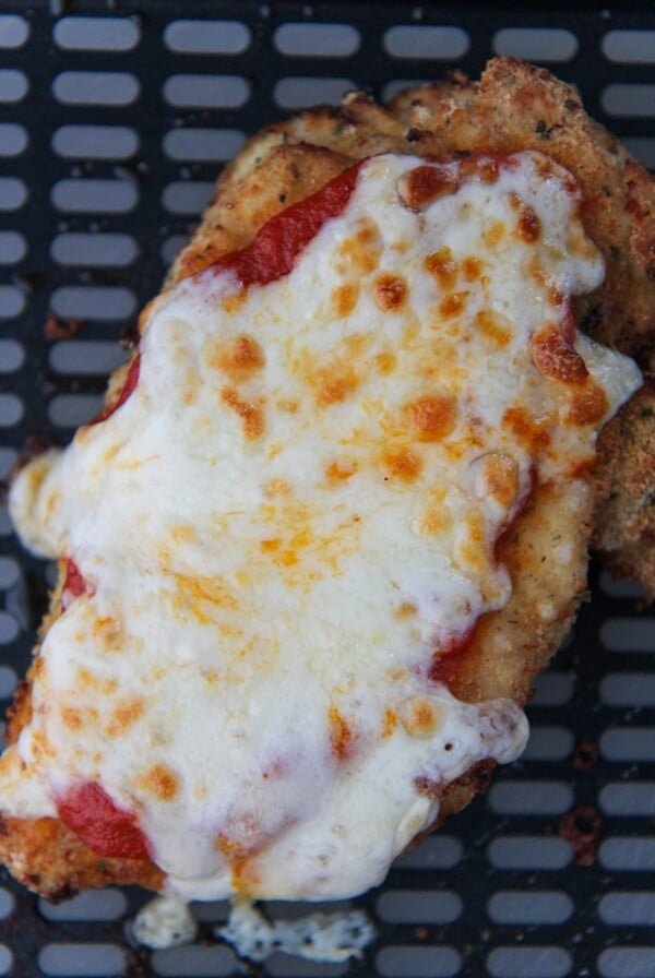 chicken parmesan in the black air fryer basket.
