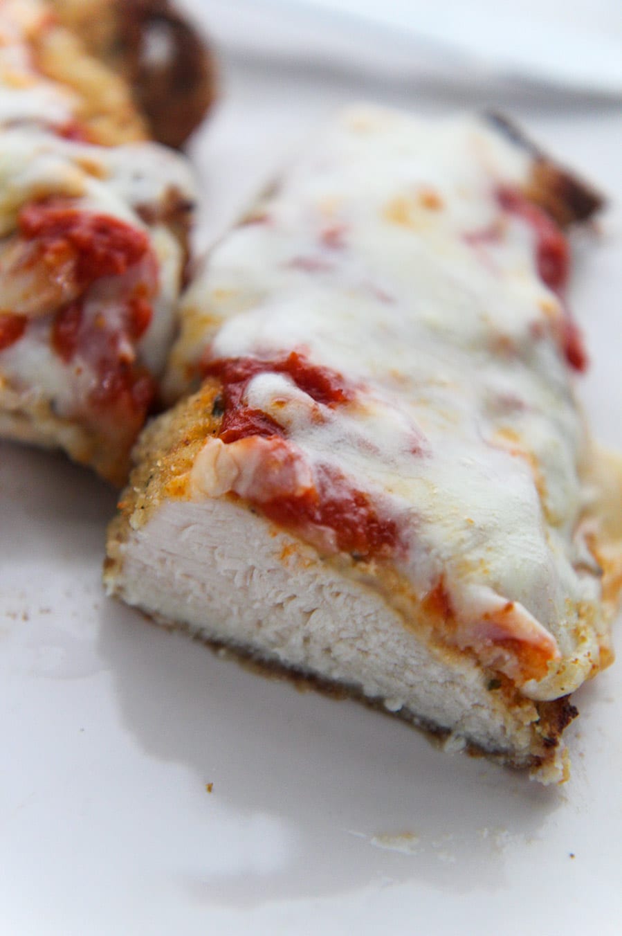 cooked chicken parm sliced in half. 