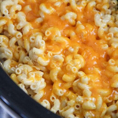 mac and cheese in the crockpot with yellow melted cheese on top