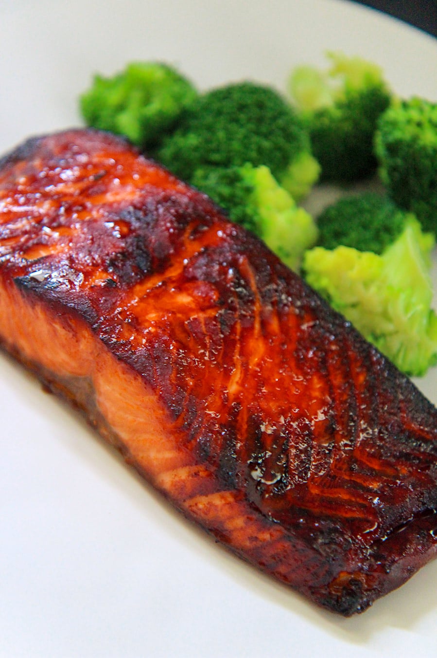 cooked air fryer salmon on a white plate with broccoli