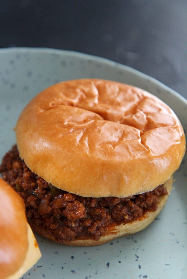 a sloppy joe up close on a blue plate.
