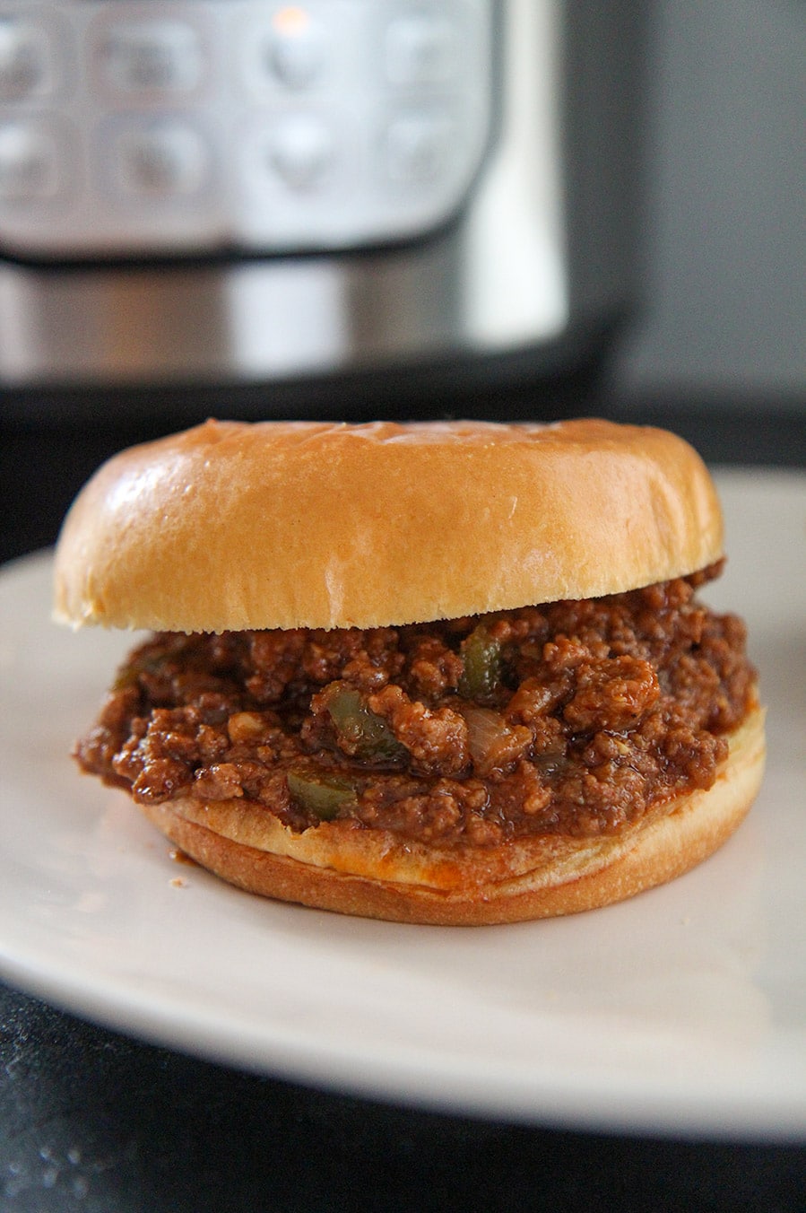 a sloppy joe sandwich with an instant pot in the background.