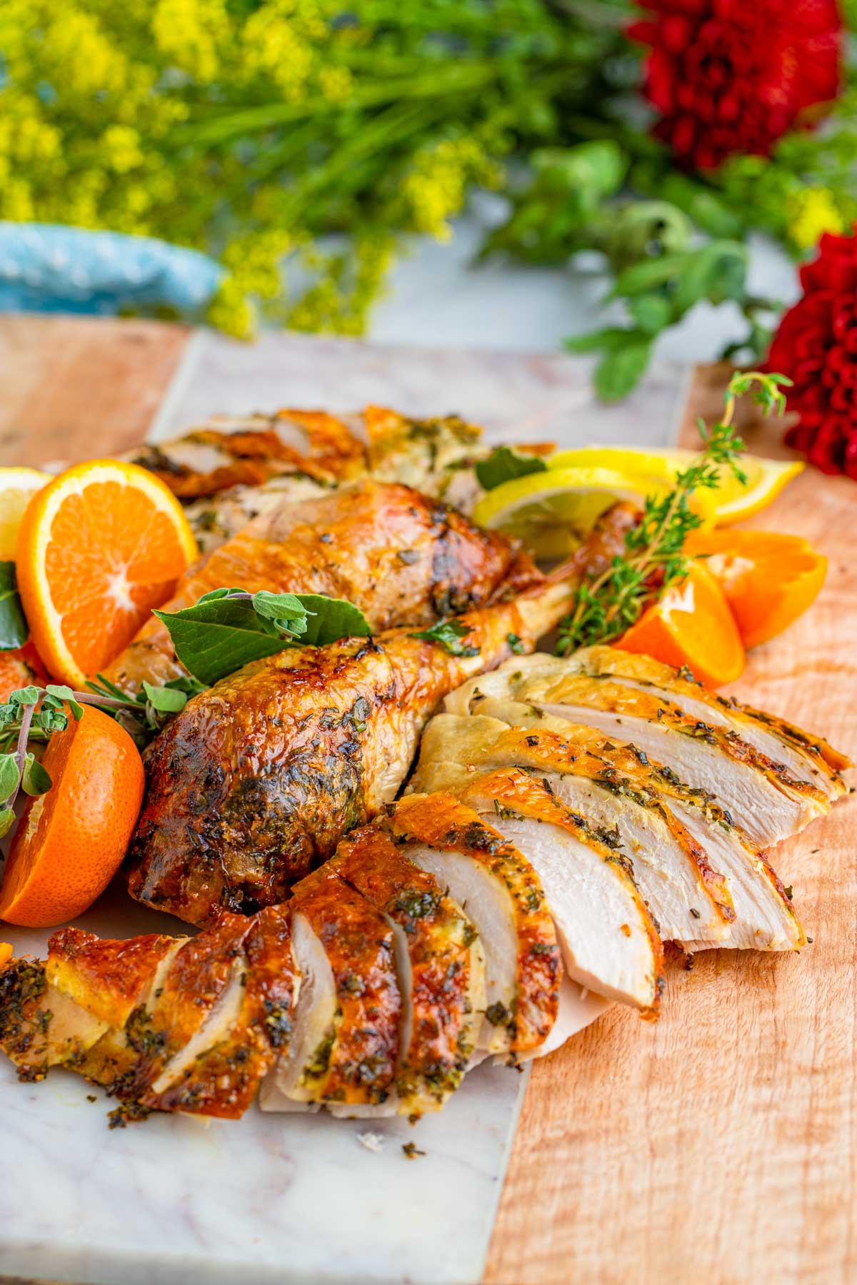 cooked turkey sliced and decorated with oranges and fresh herbs. 