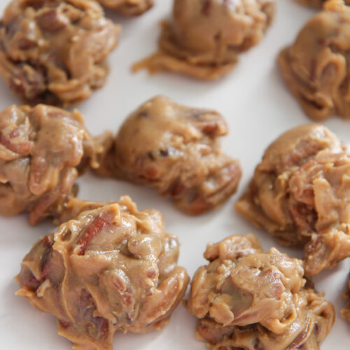 pecan pralines on a white plate.