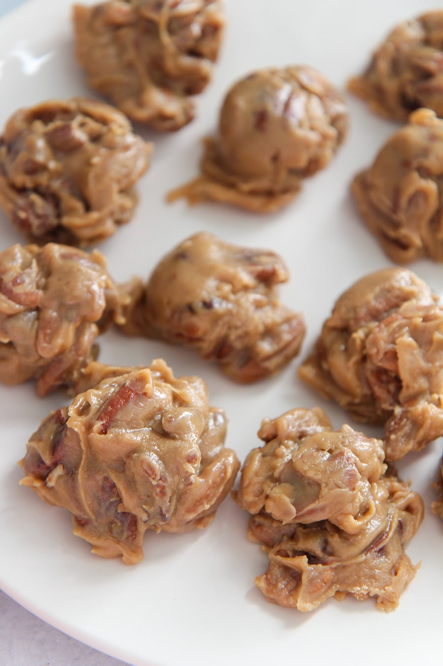 pecan pralines on a white plate.