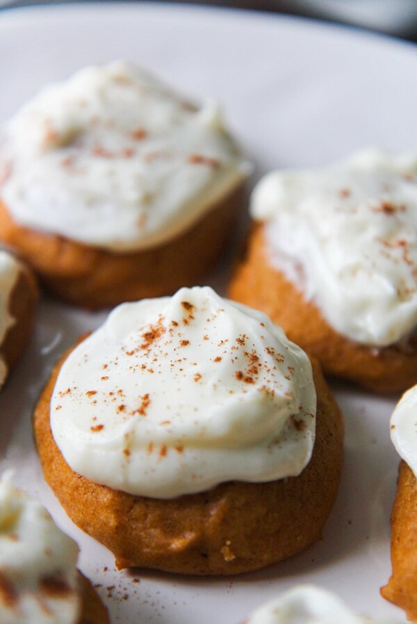 pumpkin cookies with cream cheese frosting and cinnamon on top.