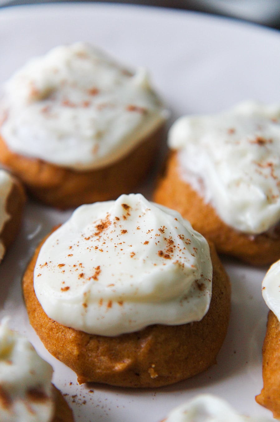 pumpkin cookies with cream cheese frosting and cinnamon on top. 